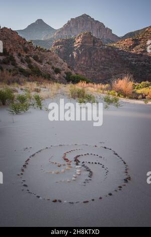 Décoration en spirale bordée de pierres sur le sable dans le terrain de camping Echo Park, Dinosaur Nation Monument, Utah et Colorado, États-Unis Banque D'Images