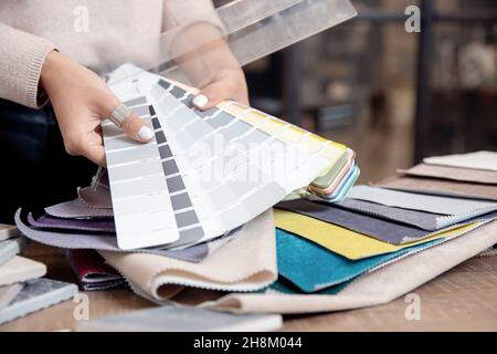 Femme décoratrice d'intérieur, décorateur choisit des tissus pour le mobilier de rembourrage, rideaux en tissu pour le projet d'appartement. Banque D'Images