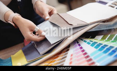 Femme décoratrice d'intérieur, décorateur choisit des tissus pour le mobilier de rembourrage, rideaux en tissu pour le projet d'appartement. Banque D'Images