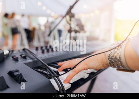 Gros plan de la main de la musicienne de rue femme jouant sur le piano mobile. Banque D'Images