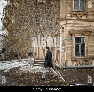 15 octobre 2016, Russie, Tomsk, homme, valse dans la rue avec de vieilles maisons en bois sur le fond Banque D'Images