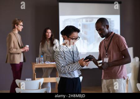 Femme d'affaires prenant le numéro de téléphone de son collègue après le séminaire d'affaires Banque D'Images