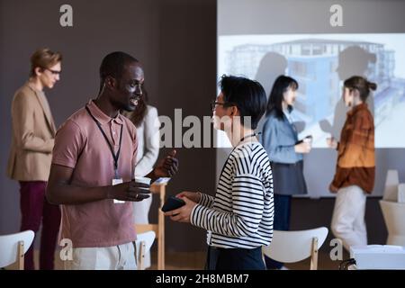 Deux collègues se rencontrent au séminaire et partagent leurs contacts lors du réseautage Banque D'Images