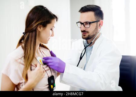 Patient gai testé avec Sphygmomanomètre par le jeune médecin. Banque D'Images