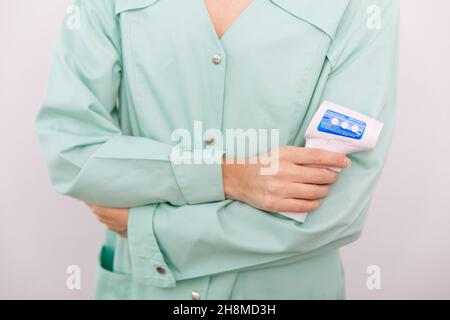 Pistolet de mesure de température dans les mains du médecin.Gros plan d'un médecin portant un masque chirurgical de protection prêt à l'emploi thermomètre infrarouge isométrique Banque D'Images