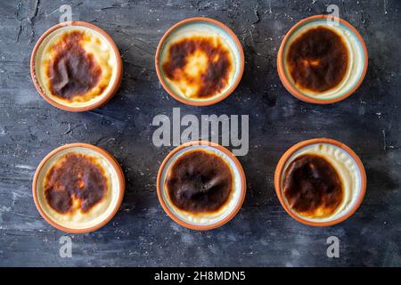 Dessert au riz cuit dans un pot d'argile au four.Prêt à servir sur un tableau de présentation noir Banque D'Images