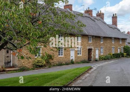 Terrasse de jolies maisons de chaume en pierre dans le village d'Ashby St Ledgers, Northamptonshire, Royaume-Uni Banque D'Images