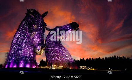 The Kelpies - grandes statues de chevaux représentant les esprits de l'eau, illuminées dans les rares lumières pourpre au coucher du soleil - situé à Helix Park, Falkirk, Royaume-Uni Banque D'Images