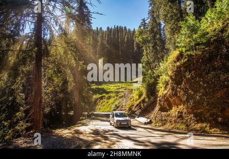 Voiture touristique en voiture le long de la route nationale de montagne sur la route de Sangla, Himachal Pradesh, Inde avec vue sur le paysage pittoresque de l'Himalaya Banque D'Images