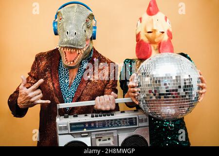 Fou couple écoutant de la musique avec boombox stéréo vintage à la fête - Focus sur l'homme masque de visage Banque D'Images