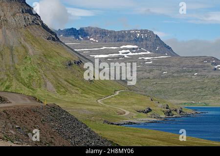 Vents étroits et non pavés le long des montagnes et de la mer, Djupavik, Westfjords, Islande Banque D'Images