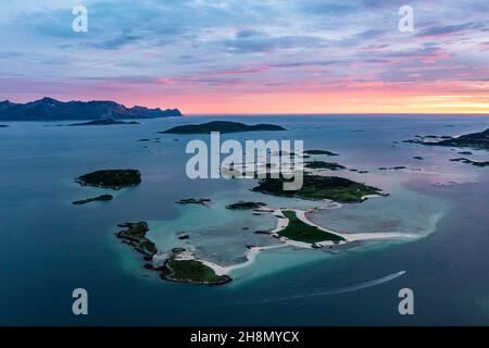 Vue de petites îles dans la mer près de Sommaroy, montagnes de l'île Senja à l'arrière, vue aérienne au coucher du soleil, Kvaloya, Troms og Finnmark, Norvège