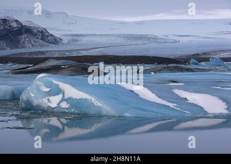 Icebergs dans le lagon du glacier Joekulsarlon, avec réflexion, derrière le glacier Breioamerkurjoekull, parc national de Vatnajoekull, Islande du Sud Banque D'Images