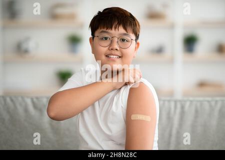 Gros plan d'un garçon asiatique heureux a été vacciné contre le coronavirus Banque D'Images