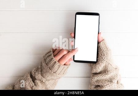 Vue de dessus d'une fille dans un chandail à l'aide d'un smartphone Banque D'Images
