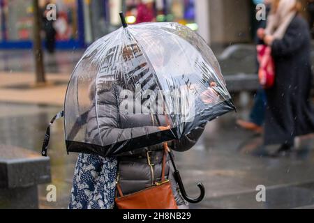 Parapluie emblématique en forme de dôme couvrant la tête et les épaules à Southport, dans le Lancashire.Météo Royaume-Uni 01 décembre 2021.Magasins de Noël, shopping lors d'une journée humide et venteuse dans le centre-ville.La pluie de ce matin se défera vers le sud, mais des vents du nord frais à modérés persisteront à ajouter un facteur de refroidissement considérable.Crédit MediaWorldImages/AlamyLiveNews Banque D'Images