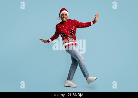 Joyeux afro-américain fêtant Noël sur fond bleu Banque D'Images