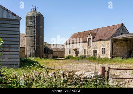 Un silo moderne et une ancienne grange dans le village de Turkdean, Gloucestershire, Royaume-Uni Banque D'Images