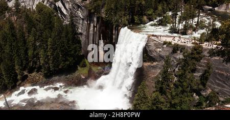 Les touristes affluent vers les chutes de Lower Yosemite dans le parc national de Yosemite lors d'un après-midi de printemps. Banque D'Images