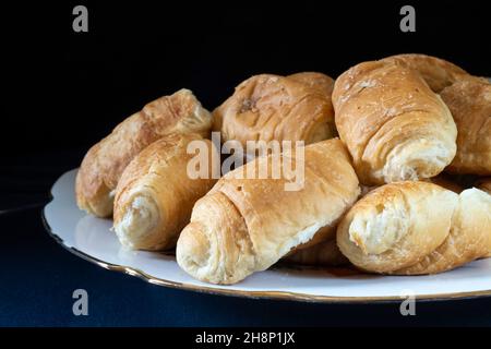 Croissants sucrés dans une assiette sur la table.Nourriture sur fond noir Banque D'Images