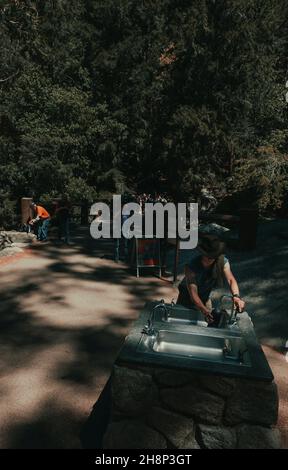 Les touristes affluent vers les chutes de Lower Yosemite dans le parc national de Yosemite lors d'un après-midi de printemps. Banque D'Images