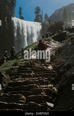 Les touristes affluent vers les chutes de Lower Yosemite dans le parc national de Yosemite lors d'un après-midi de printemps. Banque D'Images