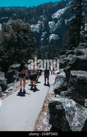 Les touristes affluent vers les chutes de Lower Yosemite dans le parc national de Yosemite lors d'un après-midi de printemps. Banque D'Images