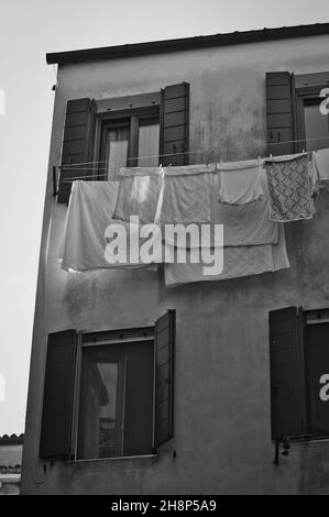 Photo en niveaux de gris de linge mouillé suspendu sur des cordes Banque D'Images