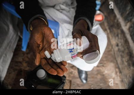 Nairobi, Kenya.1er décembre 2021.Une femme prend ses médicaments antirétroviraux (ARV) lors de la Journée mondiale contre le sida à Kibera.comme aujourd'hui marque 33 ans depuis le début de la Journée mondiale contre le sida et 40 ans depuis le premier cas de VIH,C'est également l'un des plus grands jours pour aider à mettre fin aux inégalités qui entraînent le sida et d'autres pandémies à travers le monde.Crédit : SOPA Images Limited/Alamy Live News Banque D'Images