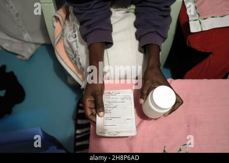 Nairobi, Kenya.1er décembre 2021.Une femme se prépare à prendre ses médicaments antirétroviraux (ARV) lors de la Journée mondiale du sida à Kibera.comme c'est aujourd'hui 33 ans depuis le début de la Journée mondiale du sida et 40 ans depuis le premier cas de VIH,C'est également l'un des plus grands jours pour aider à mettre fin aux inégalités qui entraînent le sida et d'autres pandémies à travers le monde.Crédit : SOPA Images Limited/Alamy Live News Banque D'Images