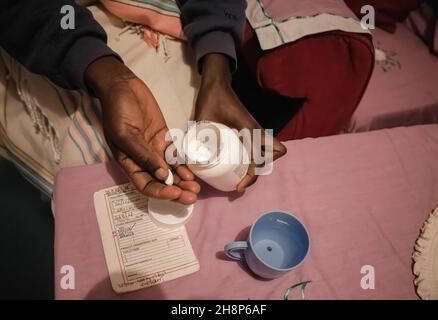 Nairobi, Kenya.1er décembre 2021.Une femme prend ses médicaments antirétroviraux (ARV) lors de la Journée mondiale contre le sida à Kibera.comme aujourd'hui marque 33 ans depuis le début de la Journée mondiale contre le sida et 40 ans depuis le premier cas de VIH,C'est également l'un des plus grands jours pour aider à mettre fin aux inégalités qui entraînent le sida et d'autres pandémies à travers le monde.Crédit : SOPA Images Limited/Alamy Live News Banque D'Images