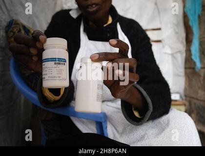 Nairobi, Kenya.1er décembre 2021.Une femme tient ses flacons de pilules antirétroviraux (ARV) pendant la Journée mondiale du sida à Kibera.comme aujourd'hui marque 33 ans depuis le début de la Journée mondiale du sida et 40 ans depuis le premier cas de VIH,C'est également l'un des plus grands jours pour aider à mettre fin aux inégalités qui entraînent le sida et d'autres pandémies à travers le monde.Crédit : SOPA Images Limited/Alamy Live News Banque D'Images