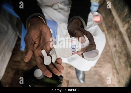 Nairobi, Kenya.1er décembre 2021.Une femme prend ses médicaments antirétroviraux (ARV) lors de la Journée mondiale contre le sida à Kibera.comme aujourd'hui marque 33 ans depuis le début de la Journée mondiale contre le sida et 40 ans depuis le premier cas de VIH,C'est également l'un des plus grands jours pour aider à mettre fin aux inégalités qui entraînent le sida et d'autres pandémies à travers le monde.Crédit : SOPA Images Limited/Alamy Live News Banque D'Images