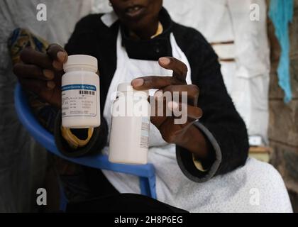 Nairobi, Kenya.1er décembre 2021.Une femme tient ses flacons de pilules antirétroviraux (ARV) pendant la Journée mondiale du sida à Kibera.comme aujourd'hui marque 33 ans depuis le début de la Journée mondiale du sida et 40 ans depuis le premier cas de VIH,C'est également l'un des plus grands jours pour aider à mettre fin aux inégalités qui entraînent le sida et d'autres pandémies à travers le monde.(Photo de Donwilson Odhiambo/SOPA Images/Sipa USA) crédit: SIPA USA/Alay Live News Banque D'Images