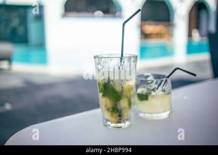 Cocktail Mojito au bord de la piscine du complexe. Concept de vacances de luxe. Arrière-plan de la piscine extérieure. Verres à cocktail au bord de la piscine, piscine floue Banque D'Images