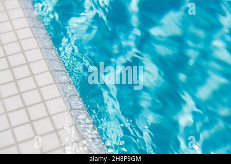 Surface de la piscine bleue. Sports nautiques d'été, arrière-plan de loisirs. Texture de la surface de l'eau, bleu turquoise vif vif ensoleillé gros plan. Détendez-vous Banque D'Images