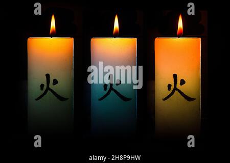 Trois bougies japonaises allumées sur fond noir Banque D'Images