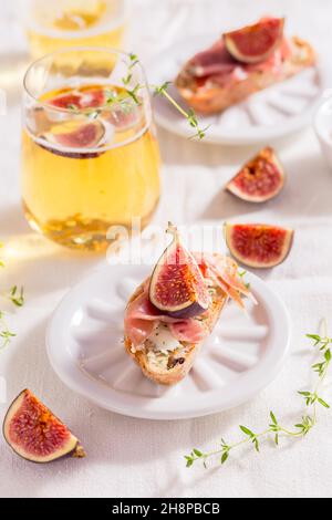 Petite collation de canapés, crostini au jambon, vin de figues et de pommes, antipasti italiens Banque D'Images