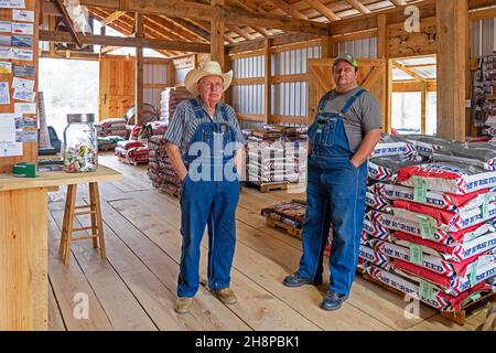 Deux agriculteurs texans portant des salopettes et des chapeaux de cowboy dans le magasin d'alimentation du bétail de bon Wier dans l'est du comté de Newton, Texas, États-Unis / États-Unis Banque D'Images