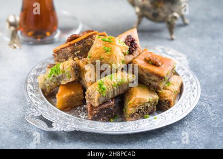 Desserts turcs traditionnels, Baklava et thé.Croustillant assorti sur plaque argentée. Banque D'Images