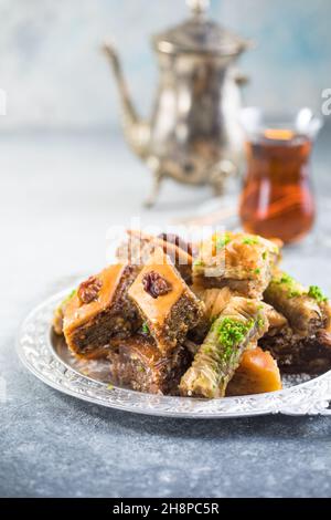 Desserts turcs traditionnels, Baklava et thé.Croustillant assorti sur plaque argentée. Banque D'Images