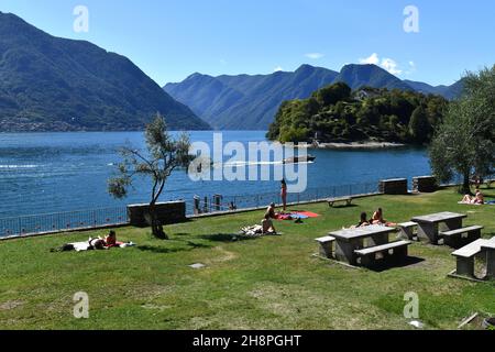 Les gens se bronzer sur la plage publique d'Ossuccio, le lac de Côme, en Italie Banque D'Images