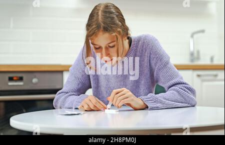 Écolière effectuant un test d'antigène COVID-19 express à la maison. Banque D'Images