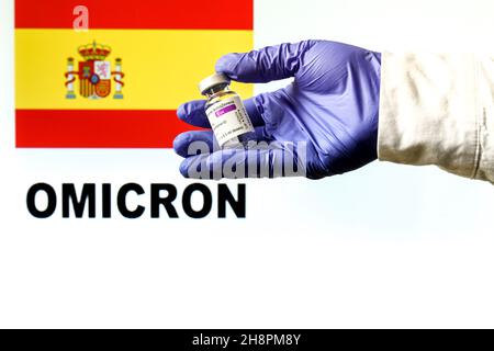 Madrid, Espagne - 29 novembre 2021 : flacon à main avec le vaccin AstraZeneca Covid.Drapeau espagnol et Omicron covid variante mot écrit dans le backgro Banque D'Images