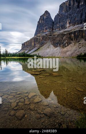 Les nuages se déplacent autour des arbres avec réflexion de la montagne sur le lac sous la pluie. Banque D'Images