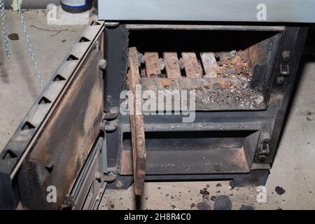 Nettoyage de la chaudière à combustible solide des restes de bois de chauffage et de charbon.Chaudière avec amortisseur ouvert.Efficacité de chauffage dans la maison. Banque D'Images