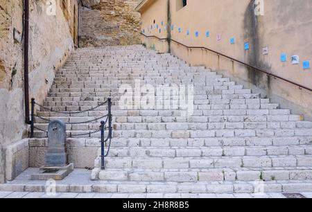 Un vieux escalier historique mène, entre de vieux murs, dans une vieille ville du sud de l'Europe Banque D'Images