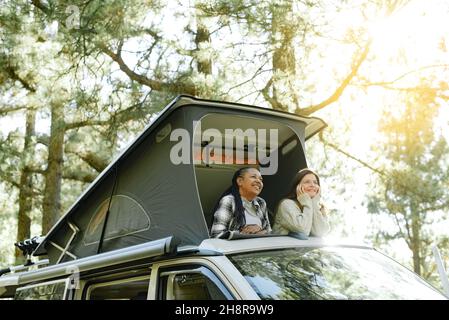 Diverses femmes voyageant se détendant dans la tente sur le toit de la voiture Banque D'Images