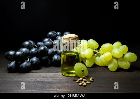 Bouteille d'huile de pépins de raisin naturel sur table en bois sombre.Espace pour le texte.Cosmétique biologique Banque D'Images