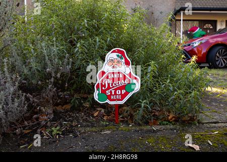 « Anta Please STOP HERE » affiche de Noël dans un jardin devant une maison à Surrey en décembre Banque D'Images